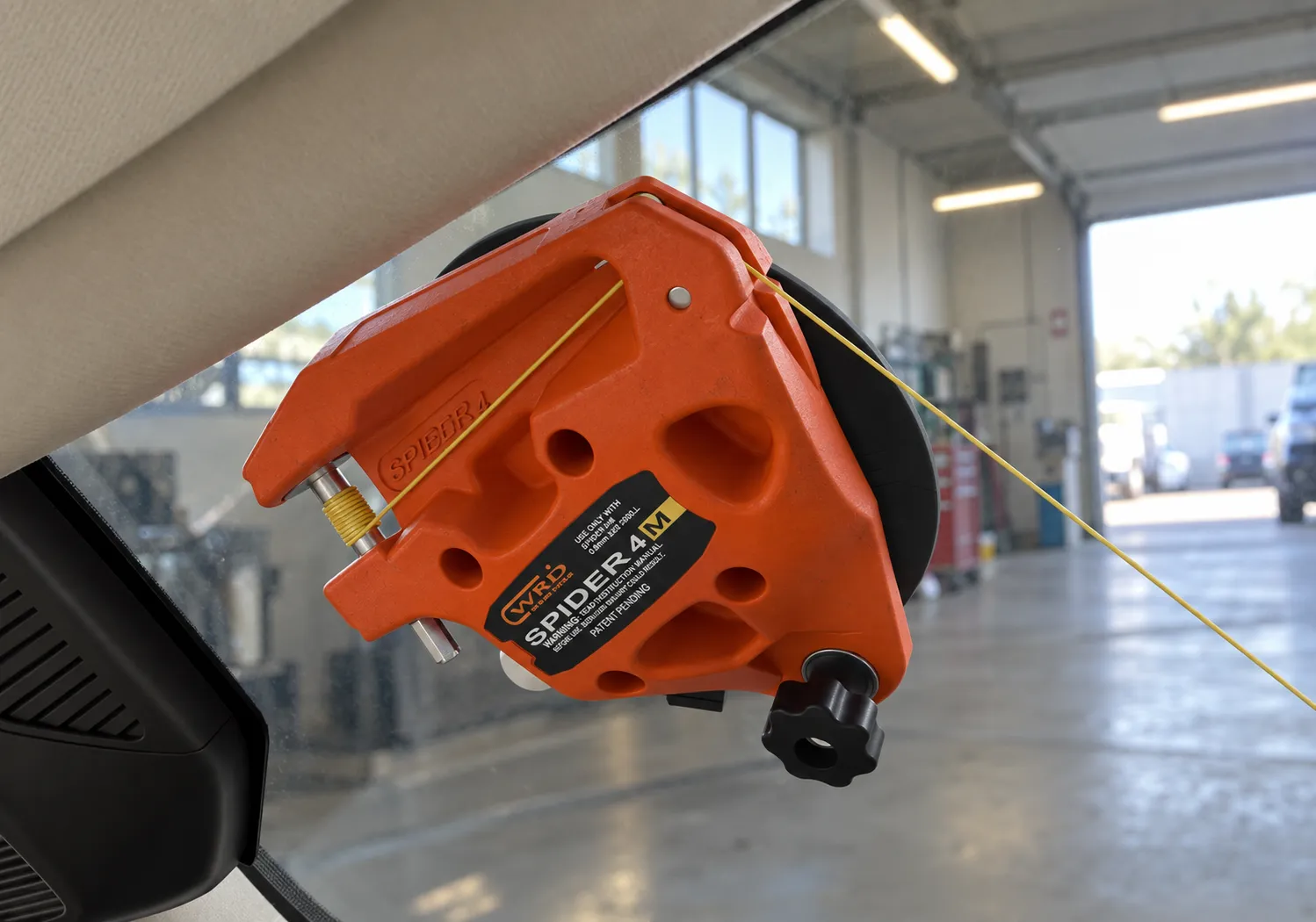 Close view of Spider 4M on the inside of the glass with yellow cutting line running from the frame